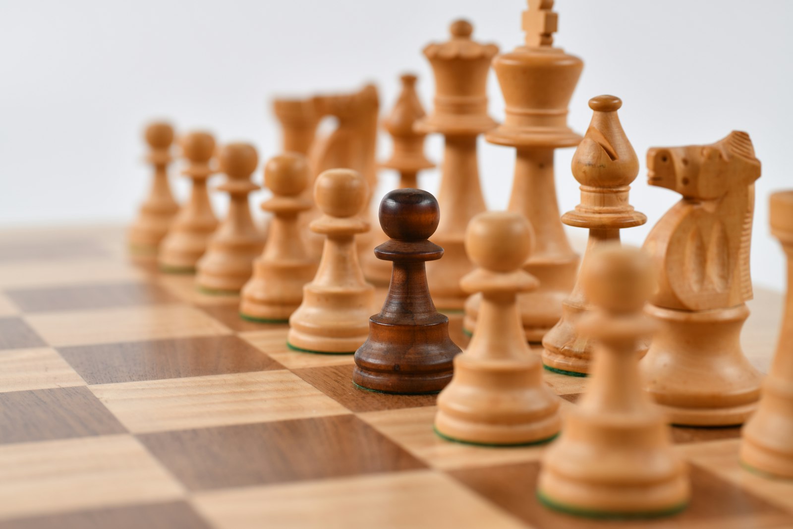 Wooden chess pieces facing off